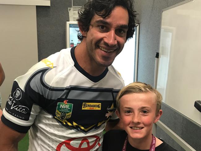 Johnathan Thurston with Guy Brennan, 12, son of Gold Coast Titans coach Garth Brennan, who received the champion Cowboys' headgear at halftime in his final NRL match.