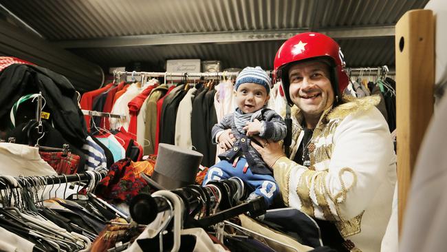 Performer John X is cleaning out his shed full of Theatre clothes and props and rather than selling he's giving it away to schools and groups. John's son Theo (7 months) is helping adjudicate. Picture: MATHEW FARRELL