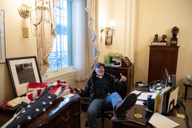 A supporter of US President Donald Trump sits inside the office of US Speaker of the House Nancy Pelosi. Picture: SAUL LOEB / AFP