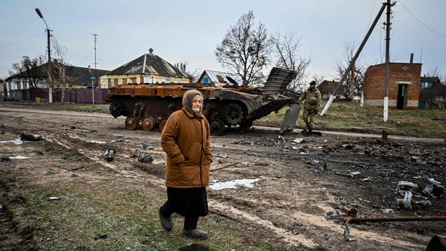 A woman walks past a destroyed armoured personal carrier in the liberated village of Petropavlivka near Kupiansk, Kharkiv region. Picture: AFP