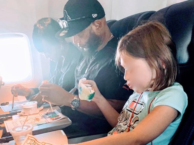 A little girl paints with strangers on a plane. Picture: Josh Haltom