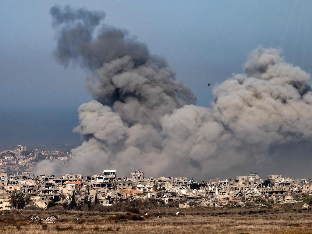 Smoke rises from explosions above destroyed buildings in the northern Gaza Strip on January. (Photo by Menahem KAHANA / AFP)