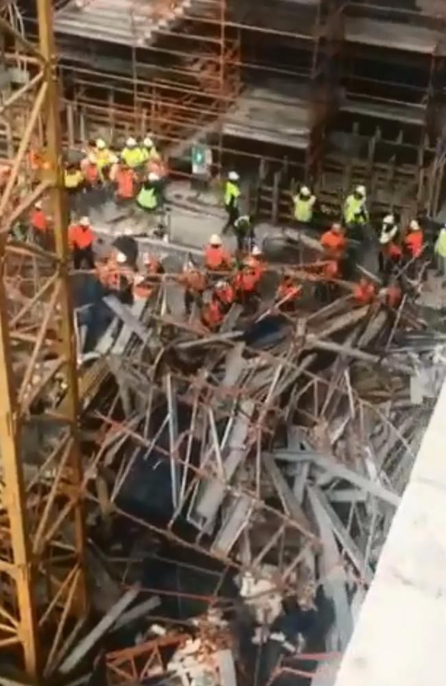 The chaotic scene moments after the collapse as tradies rushed to the aid of the two men trapped underneath the scaffolding. Picture: 7 News