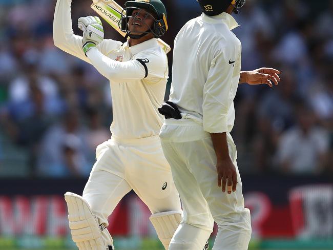 Usman Khawaja of Australia hits a shot in the air off Ravi Ashwin