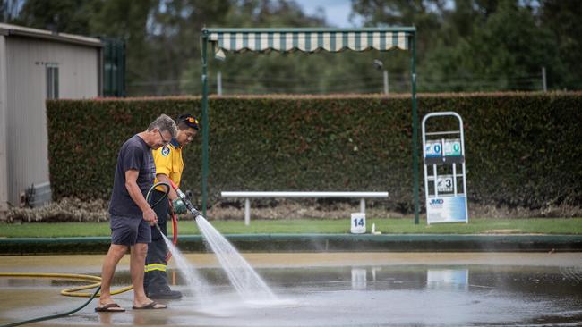 RFS volunteers from Gledswood Hills washed mud off the bowling greens. Picture: Julian Andrews