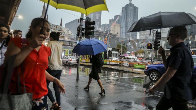 Face masks were replaced by umbrellas yesterday. Picture: Wayne Taylor