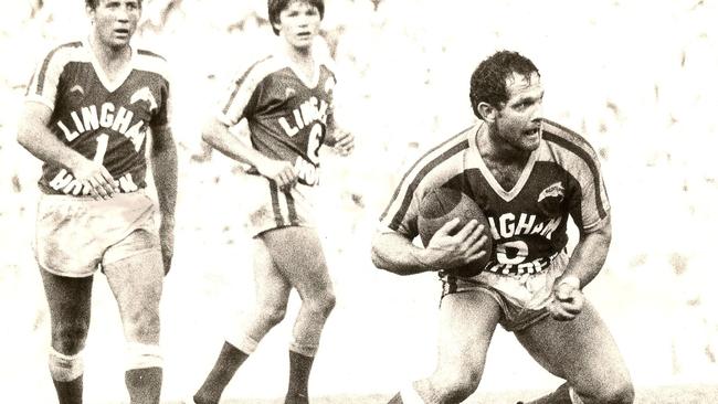 Tony Obst playing for the Redcliffe Dolphins, with Ian Bunny Pearce and Trevor Benson in the background.