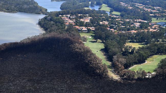 Golfers on the green next to a bushfire-damaged area in Noosa Heads on the Sunshine Coast. Queensland firefighters have been forced to rethink the definition of normal.