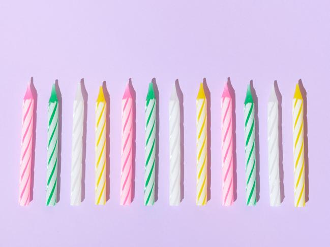 Coloruful birthday candles on a purple background. Birthday celebration candle concept aesthetic.