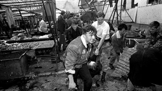 Rescue workers remove the body of victim following mortar attack on Sarajevo market in 1994.