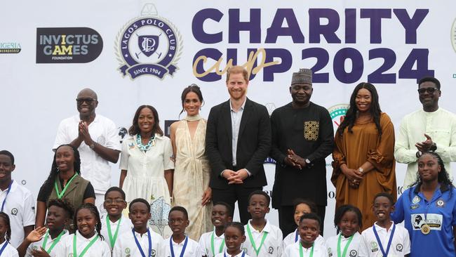 Harry, Duke of Sussex, and Meghan, Duchess of Sussex pose for a photo with children after a charity polo game in Lagos during a visit to Nigeria. Picture: Kola Sulaimon/AFP