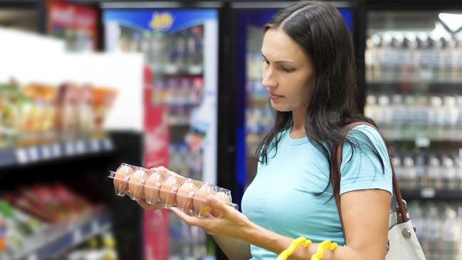 woman shopping checking prices concerned worried supermarket retail for insight story on falling sentiment