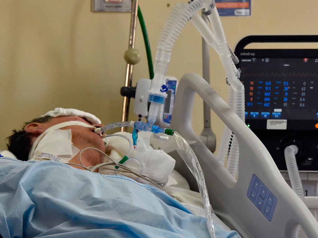 A Covid-19 patient lies in bed in an ICU ward. The oral pills are designed to prevent hospitalisation and death. Picture: AFP