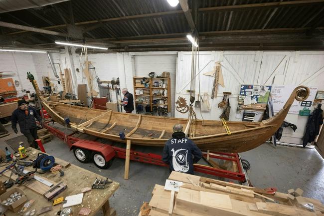 Veterans put the finishing touches to a Viking longboat built from solid oak using authentic Scandinavian plans as part of a project to help restore their mental health