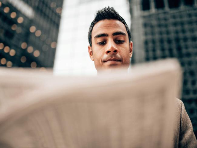 indian business man reading newspaper in manhattan