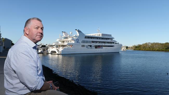 Gold Coast City Marina and Shipyard director Trenton Gay sitting in front of a 60-metre superyacht at the marina at Coomera. Picture Glenn Hampson