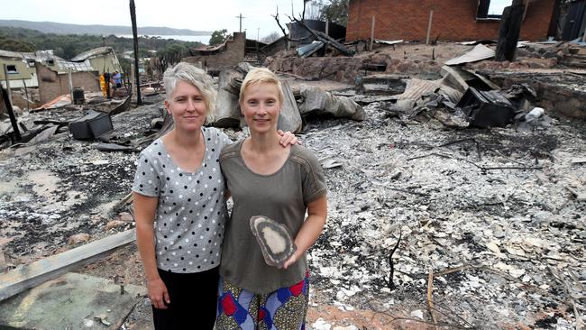 Stoic couple Deborah Nave (left) and Ingrid Mitchell stand among ruins as they return to see their destroyed house for the first time after Sunday's devastating fires at Tathra on the NSW South Coast. Pictrures: Ray Strange.