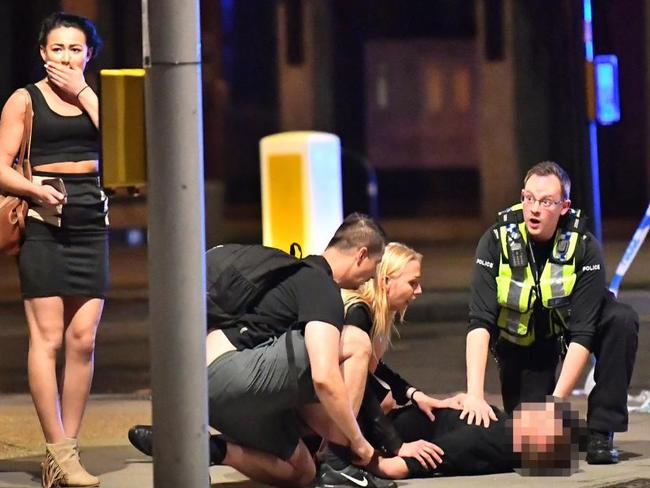 Bystanders and police rush to assist a man caught up in the terror attack in London. Picture: Supplied