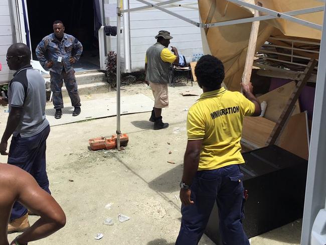 Stills taken on Manus Island, on Thursday, showing Papua New Guinea officials dismantling compounds at the detention centre.