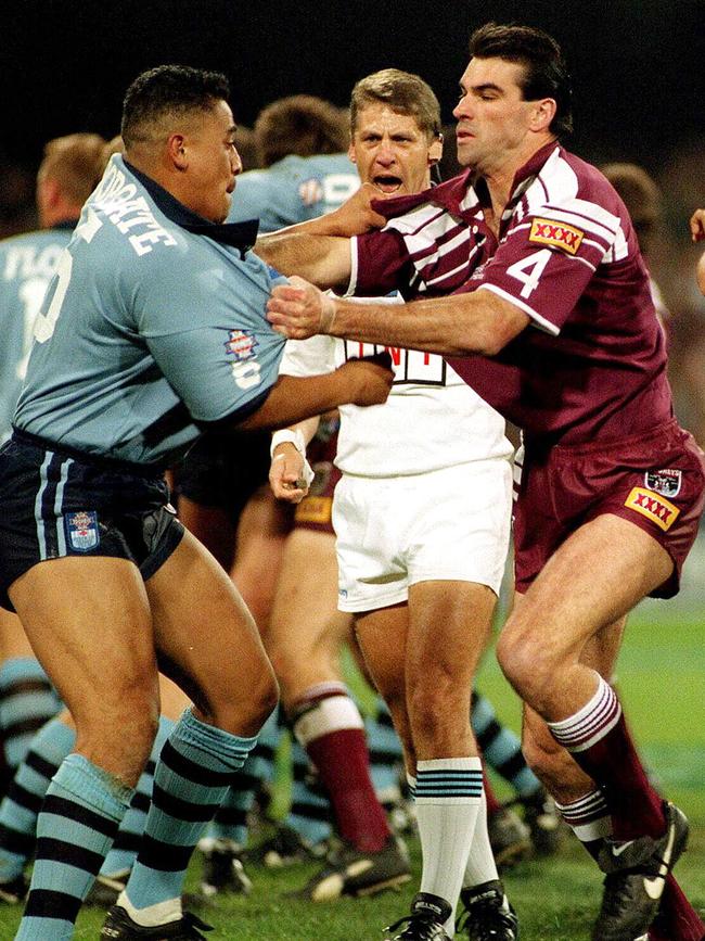 Referee Eddie Ward (centre) watches as John Hopoate (left) and Danny Moore slug it out. Photo: File