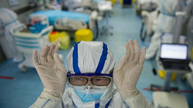 A nurse adjusts his goggles in an intensive care unit treating COVID-19 coronavirus patients at a hospital in Wuhan, in China's central Hubei province.