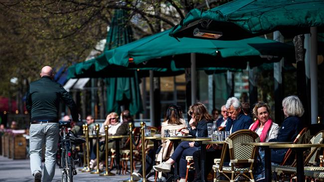 People sit in a restaurant in Stockholm which now has the highest death rate in Europe. Picture: AFP.