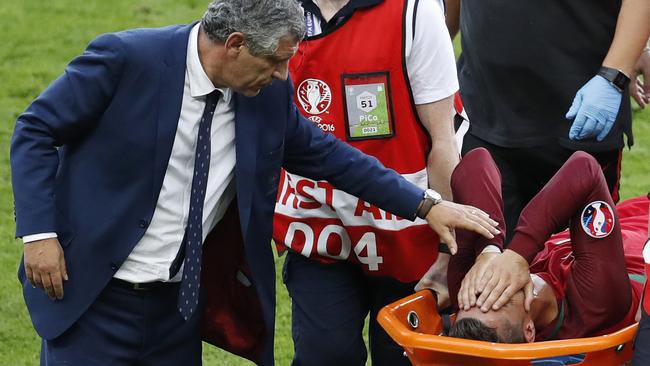 Cristiano Ronaldo is comforted by Portugal manager Fernando Santos.