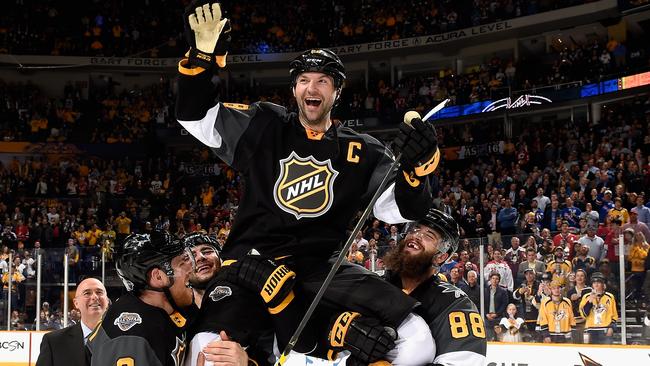 NASHVILLE, TN - JANUARY 31: John Scott #28 of the Arizona Coyotes is held up by teammates Mark Giordano #5 of the Calgary Flames and Brent Burns #88 and Joe Pavelski #8 of the San Jose Sharks of the Pacific Division All-Stars of the Western Conference after defeating the Atlantic Division All-Stars of the Eastern Conference in the 2016 Honda NHL All-Star Final Game at Bridgestone Arena on January 31, 2016 in Nashville, Tennessee. The Pacific Divisoin All-Stars of the Western Conference defeated the Atlantic Division All-Stars of the Eastern Conference 1-0. (Photo by Brian Babineau/NHLI via Getty Images)