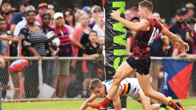 Jake Melksham of the Demons kicks a goal in front of David Mackay. Picture: AAP Image/Mark Brake