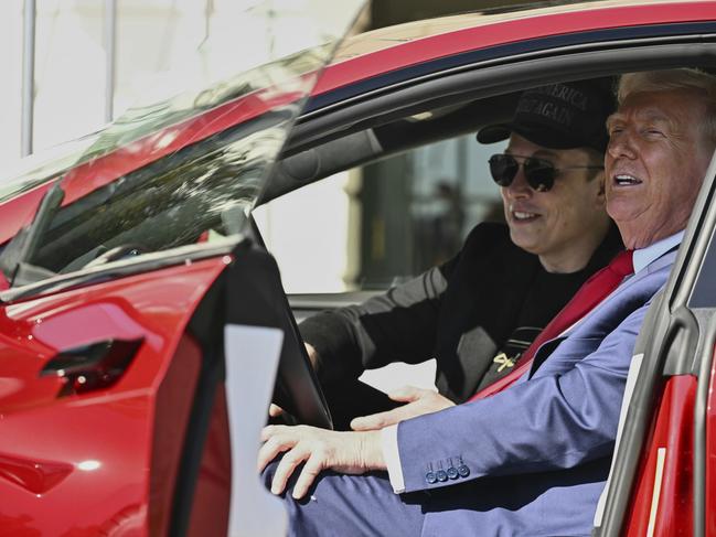 President Donald Trump and Tesla CEO Elon Musk speak to reporters as they sit in a red Model S Tesla vehicle on the South Lawn of the White House. Picture: Pool via AP