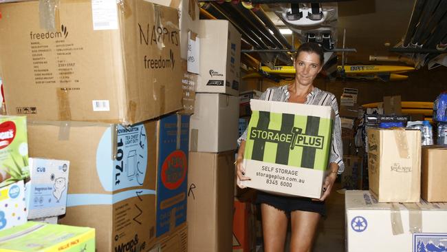 Volunteer Claire Favre brings another boxload of donations through the surf club garage to be loaded. Picture: John Appleyard