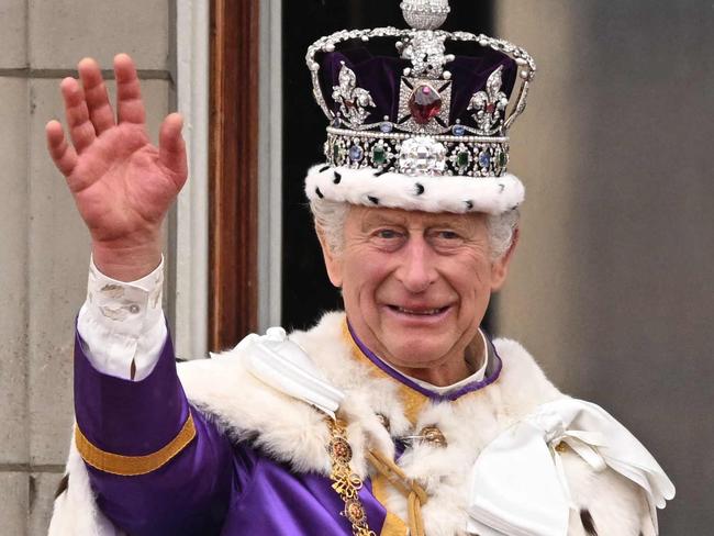 TOPSHOT - -- AFP PICTURES OF THE YEAR 2023 --  Britain's King Charles III wearing the Imperial state Crown, and Britain's Queen Camilla wearing a modified version of Queen Mary's Crown wave from the Buckingham Palace balcony after viewing the Royal Air Force fly-past in central London on May 6, 2023, after their coronations.. The set-piece coronation is the first in Britain in 70 years, and only the second in history to be televised. Charles will be the 40th reigning monarch to be crowned at the central London church since King William I in 1066. (Photo by Oli SCARFF / AFP) / AFP PICTURES OF THE YEAR 2023