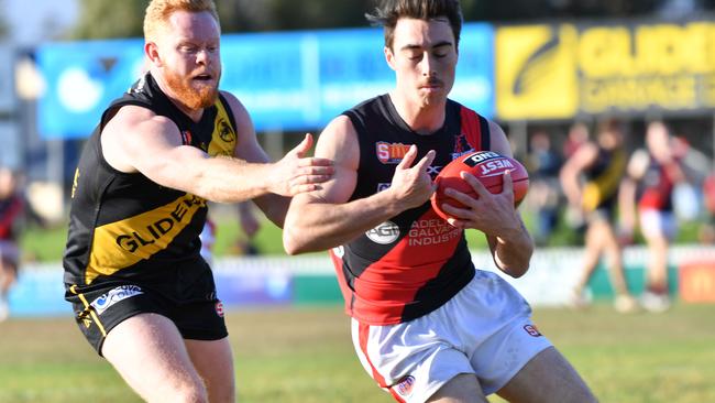 Glenelg’s Darcy Bailey tries to bring down West’s Jack Agostino. Picture: AAP/ Keryn Stevens