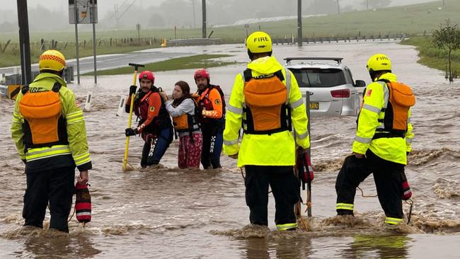 A woman is rescued after her car became trapped by flood waters at Dapto.