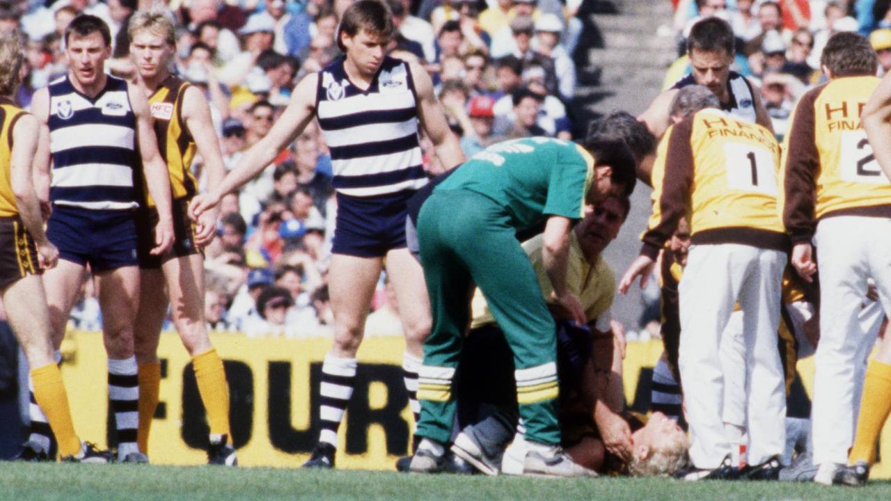 Dermott Brereton is attended to by trainers and medical staff. 1989 Grand Final. Hawthorn v Geelong. MCG. Colour. Color.