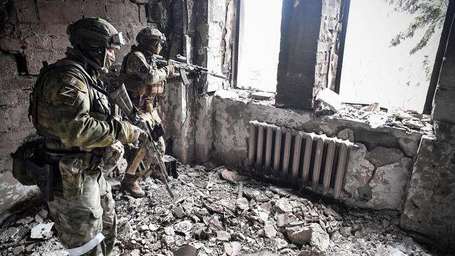 Two Russian soldiers patrol in the Mariupol drama theatre.