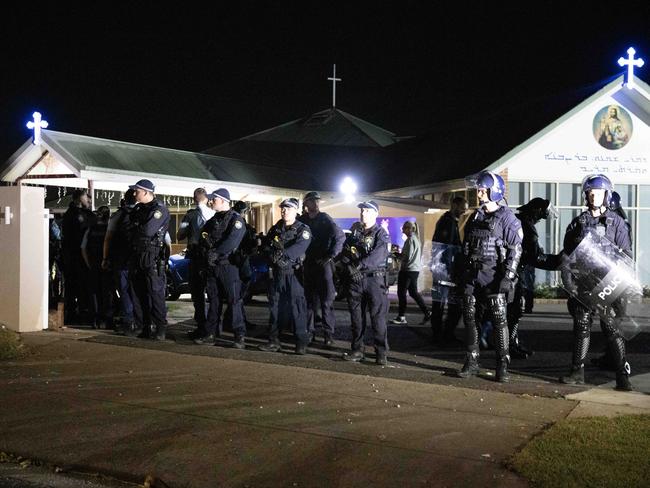 Police confronted a riotous mob outside the church where Bishop Mar Mari Emmanuel had been stabbed. Picture: Liam Mendes