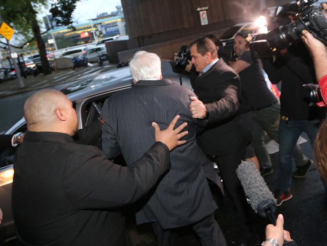 Mr Palmer is bundled into a waiting car. Picture: Jono Searle
