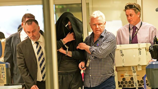 Aaron Donald Carver under heavy guard in Adelaide Airport. Picture: Tom Huntley