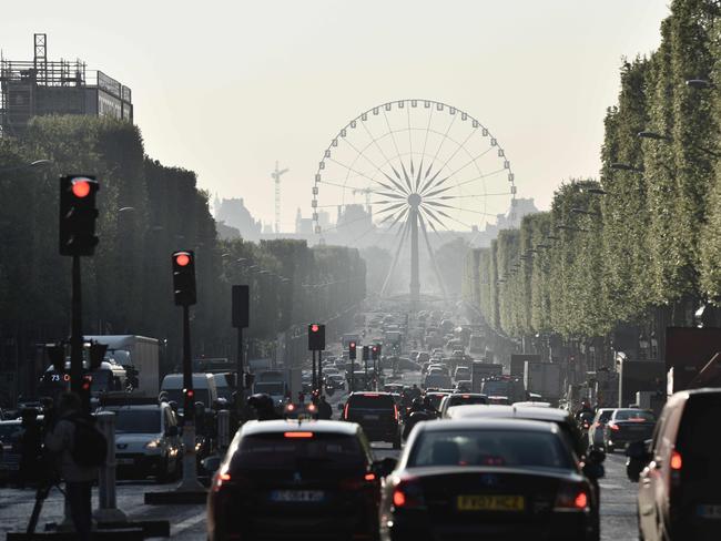 Motorists on the Champs Elysees on Friday morning with the Concorde Plaza Ferris wheel in background. Picture: AFP