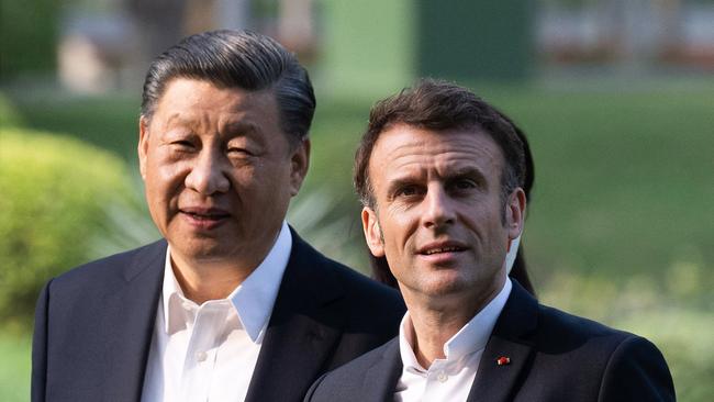 Chinese President Xi Jinping (L) and French President Emmanuel Macron (R) visit the garden of the residence of the Governor of Guangdong, on April 7, 2023.