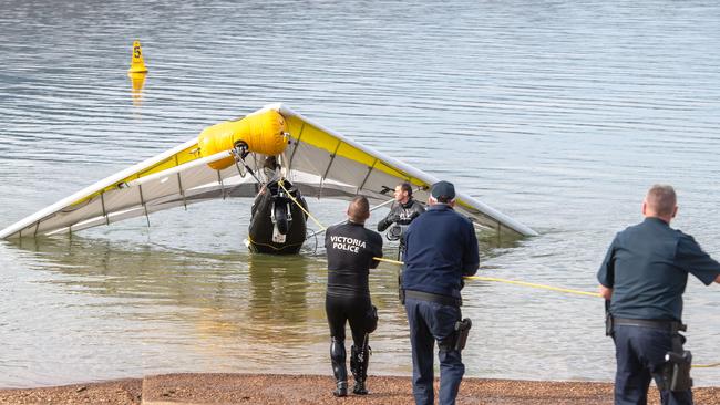 Police haul the crashed ultralight aircraft ashore. Picture: Jason Edwards