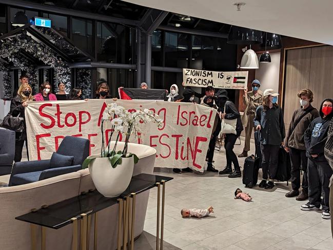 #Upsized for Print # Pro-Palestinian activists have sparked outrage after they ambushed visiting friends and families of Israeli hostages at the Melbourne hotel they were staying at.  Dozens of protesters tracked down the group of Israelis late on Wednesday night as they returned to their CBD hotel after speaking about their ordeals at an event at Mount Scopus Memorial College.