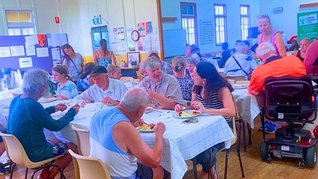 Families and those struggling make ends meet sit down to a meal at the Wynnum Community Place. Picture: Supplied.