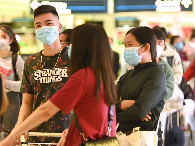 Passengers wait to check-in at the departures hall at the international airport in Sydney on March 18, 2020. - Australia urged its citizens on March 18, not to travel abroad and warned those already overseas to rush home as it imposed unprecedented steps to choke off the spread of the coronavirus epidemic taking off Down Under. (Photo by PETER PARKS / AFP)