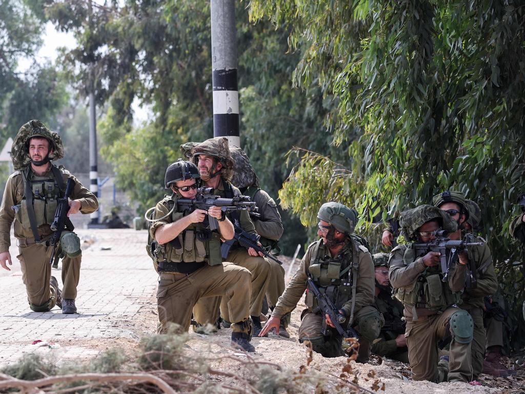 Israeli soldiers take up position in Kfar Aza, in the south of Israel, bordering the Gaza Strip. Picture: AFP