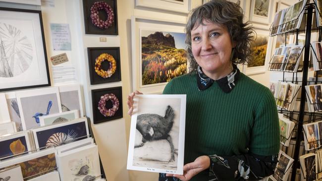 Wild Island exhibition and event co-ordinator Caroline Davies Choi holds a picture of a Native Hen by artist Geoff Tuck at Salamanca. Picture: Chris Kidd