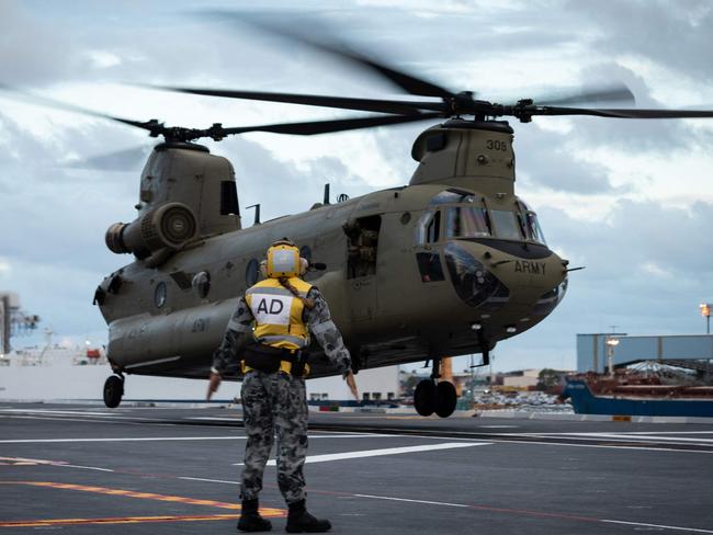 This handout photo taken on January 19, 2022 and released on January 20 by the Royal Australian Air Force and the Australian Defence Force show HMAS Adelaide embarking an Australian Army CH-47 Chinook heavy-lift helicopters before departing the port of Brisbane, to provide humanitarian assistance to Tonga following the eruption of the Hunga Tonga-Hunga Haaâpai underwater volcano on January 15. (Photo by LSIS David Cox / Australian Defence Force / AFP) / RESTRICTED TO EDITORIAL USE - MANDATORY CREDIT "AFP PHOTO / Royal Australian Air Force and the Australian Defence Force" - NO MARKETING - NO ADVERTISING CAMPAIGNS - DISTRIBUTED AS A SERVICE TO CLIENTS