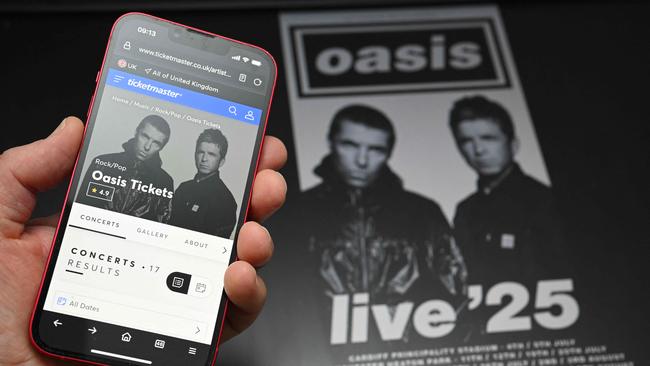 A fan uses a smart phone to access an online ticket sales website to purchase tickets for Oasis tickets. Photo: Oli SCARFF / AFP.