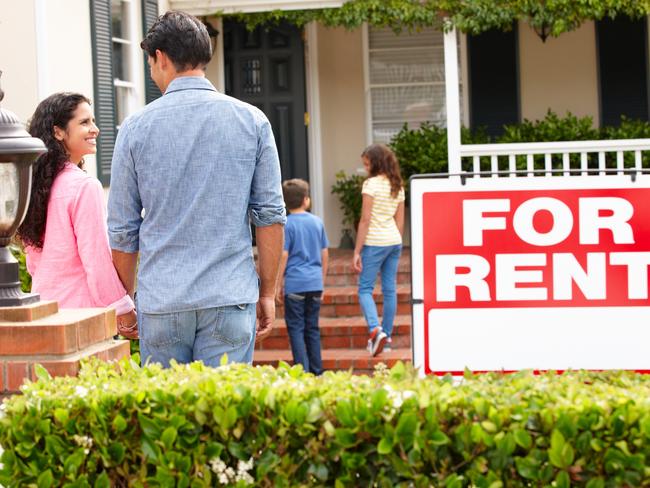 Hispanic family outside home for rent holding hands looking at each other happy